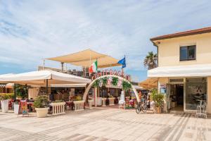 a shopping center with tables and umbrellas at Bagno Conte Rosso - Beachfront Suites & Apartments in Lido di Camaiore