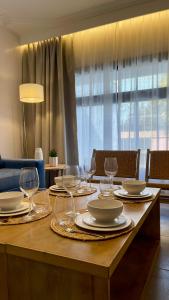 a wooden table with plates and wine glasses on it at Park Apartments in Mendoza +80 photos