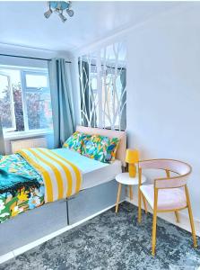 a bedroom with a bed and a chair and a window at Kaly- Relaxing Garden, Central, Close Parking, near Portsmouth Harbour Train Station, Gunwharf Quays, Southsea in Portsmouth