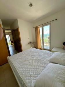 a bedroom with a large bed and a large window at Kronos in Budva