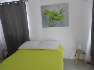 a bedroom with a green bed with a painting on the wall at Favvidea in Jan Thiel +23 photos