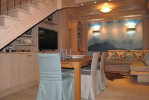 a dining room with a table and a couch at Villa Zubiana in Cortina dʼAmpezzo