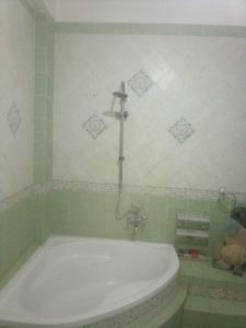 baño con bañera y una cruz en la pared en Nube's Dream House, en Luxor