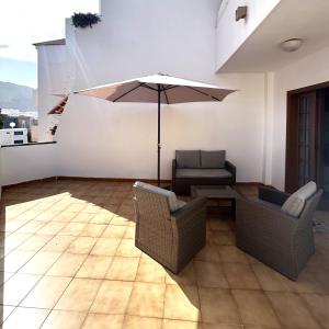a patio with a table and chairs and an umbrella at Apt In Colina 2, Los Cristianos K105 in El Guincho