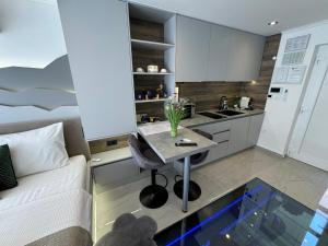 NašiceLa Luna Petite Suite Deluxe Apartment with Pool & Jacuzzi, Bikes and Covered Parking的房间里有一张桌子和一张床的小厨房