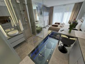 NašiceLa Luna Petite Suite Deluxe Apartment with Pool & Jacuzzi, Bikes and Covered Parking的带玻璃淋浴和水槽的浴室