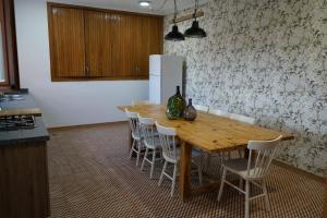 a kitchen with a wooden table with chairs and a refrigerator at Casa Rural Puentes Mediana in Olmedo