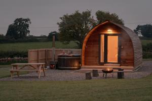 a small wooden cabin with a hot tub and a bench at Eden Valley by Wigwam Holidays in Cumwhinton