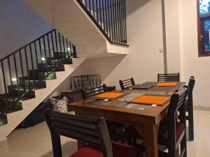 a dining room with a table and chairs and stairs at BIVORA Villa in Negombo