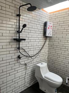 a bathroom with a shower with a toilet and a phone at Pijar Jingga Cabin in Diyeng +7 photos
