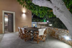 a dining room with a table and chairs and a stone wall at Alexandras's Mansion in Ayiá