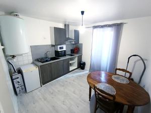 kuchnia z drewnianym stołem i jadalnią w obiekcie Le bon appart proche centre-ville w mieście Roanne