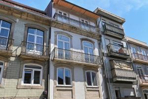 ein Gebäude mit Balkonen an der Seite in der Unterkunft Almada e Fado in Porto