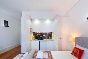 eine Küche mit weißen Schränken und einem Sofa in einem Zimmer in der Unterkunft Almada e Fado in Porto