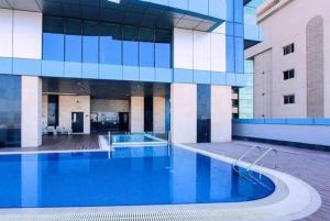 a large building with a large swimming pool at High Floor 31 with Skyline View in Manama