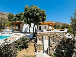 a house with a stone wall next to a pool at Stone Built Villa Ferretti in Plintri