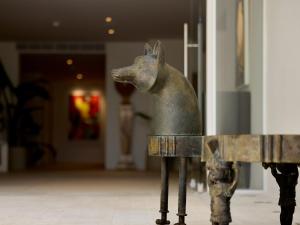 a statue of a dog standing next to a fence at The Roc Club, A Grecotel Hotel to Live in Athens