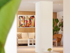 a living room with a couch and paintings on the wall at The Roc Club, A Grecotel Hotel to Live in Athens