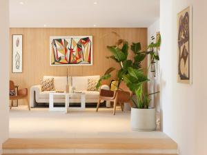 a living room with a couch and a plant at The Roc Club, A Grecotel Hotel to Live in Athens