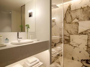 a bathroom with a sink and a mirror at The Roc Club, A Grecotel Hotel to Live in Athens