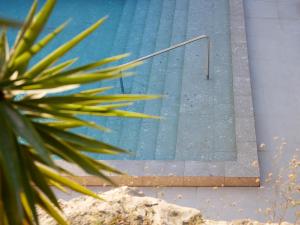 a mirror on the side of a swimming pool at The Roc Club, A Grecotel Hotel to Live in Athens