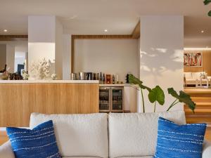 a living room with a white couch with blue pillows at The Roc Club, A Grecotel Hotel to Live in Athens
