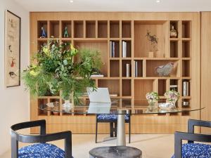 a dining room with a glass table and a book shelf at The Roc Club, A Grecotel Hotel to Live in Athens