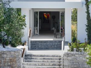 a home with stairs leading to the front door at The Roc Club, A Grecotel Hotel to Live in Athens