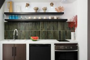 una cucina con lavandino e lavastoviglie nera di Small Historic Townhouse By Promenade Near Beaches a Portimão