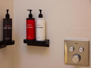 a bathroom with two shampoo bottles on a wall at The Roc Club, A Grecotel Hotel to Live in Athens