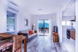 una sala de estar con un sofá y una mesa en Ilhabela Beach Residences, en Ilhabela