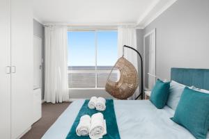 a bedroom with a bed with towels and a window at Odeon Towers 1102 in Strand