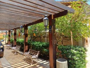 a wooden pergola with two benches and a street light at Akirá Pousada in Aquiraz