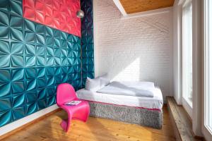 a bedroom with a bed and a pink chair at Top floor Penthouse with Garden in Berlin