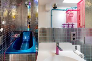 a bathroom with a sink and a blue tub at Top floor Penthouse with Garden in Berlin