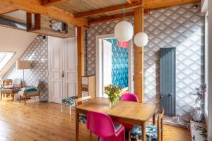 a dining room with a table and pink chairs at Top floor Penthouse with Garden in Berlin