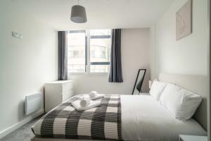 a bedroom with a black and white bed with a window at Fantastic Central Preston 1 Bedroom Apartment in Preston