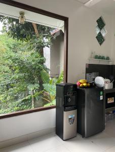 a kitchen with a window and a small refrigerator at Central House Ubud - Private Villa in Ubud +13 photos