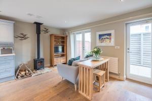 a living room with a table and a fireplace at Captain's Quarters, a ground floor apartment in Aldeburgh in Aldeburgh