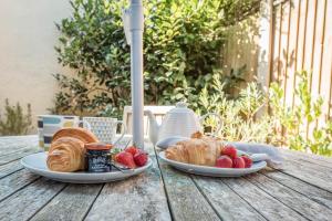 a table with two plates of croissants and strawberries at Captain's Quarters, a ground floor apartment in Aldeburgh in Aldeburgh +8 photos