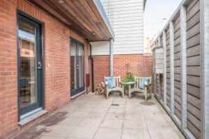 a patio with two chairs and a table next to a brick building at Captain's Quarters, a ground floor apartment in Aldeburgh in Aldeburgh