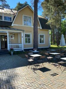 a group of tables and chairs in front of a house at Villa Solgården in Hanko