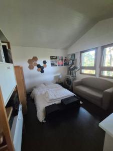 a bedroom with a bed and a couch at Seignosse Appart T2 - 500m Océan in Hossegor