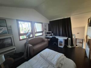 a bedroom with a bed and a couch and a desk at Seignosse Appart T2 - 500m Océan in Hossegor