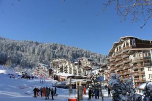 a group of people standing in the snow at a ski resort at Résidence Grand Bois A916 Clés Blanches in Courchevel