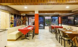 une salle à manger avec des tables et des chaises dans un restaurant dans l'établissement Hotel Crown, à Ahmedabad