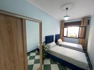 una camera da letto con due letti e una finestra di Comfy Stay in Larache's Center a Larache