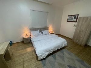 een slaapkamer met een wit bed met twee lampen bij شقق الفتح الخاصة Al Fath Private Apartments in Al Madinah +8 foto's