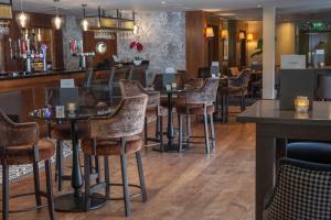 a bar with chairs and tables in a restaurant at Norton Park Hotel, Spa & Manor House - Winchester in Winchester