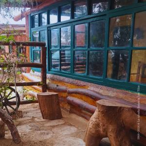 a bench in front of a building with windows at La cabaña estancia Los Tilos in Hacienda Santo Domingo